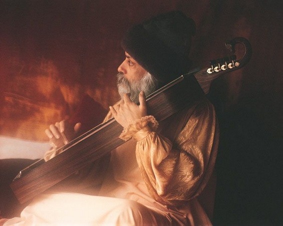 Osho playing a string instrument