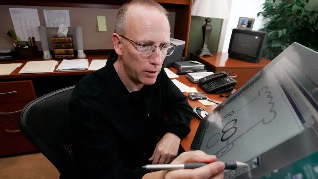 Scott Adams drawing a Dilbert comic