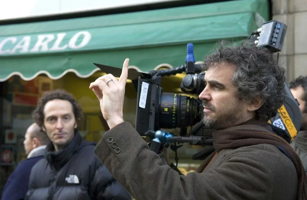 Alfonso Cuarón holding a film camera on the set of 'The Children of Men'